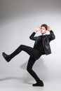 Full body image of model appearance of young fashionable guy in leather jacket and all black clothes posing on white