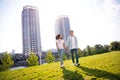 Full body length photo of beautiful couple students soulmates holding hands together looking green backyard city