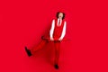 Full body length photo of elegant teenager in stylish suit with parasol makes boogie woogie simple dance isolated on red