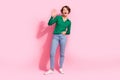 Full body length photo of friendly young lady waving palm combinated to jeans welcome you in store isolated on pink