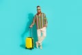 Full body length photo of handsome red hair casual tourist in trendy shirt waiting airport with baggage isolated on blue