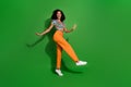 Full body length photo of young girl wearing festive retro style top and pants dancing boogie woogie isolated on green