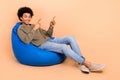 Full body length photo of young optimist guy wear stylish outfit sit bean bag comfort place indicate novelty isolated on