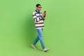 Full body photo of addicted shopping young man stylish outfit order fast food while going home use phone isolated on