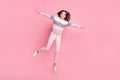 Full body photo of attractive energetic young girl jump up air make wings hands isolated on pink color background