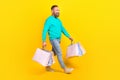 Full body photo of attractive grandpa walking shopping mall packages dressed stylish cyan garment isolated on yellow Royalty Free Stock Photo