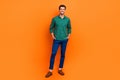 Full body photo of attractive positive brunet hair guy handsome successful entrepreneur model posing isolated on orange