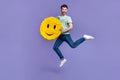 Full body photo of attractive young guy jump holding smile emoji pinata optimist wear trendy gray look isolated on