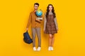 Full body photo of brunette couple wear plaid dress pants bow-tie hold bag globe books nerd isolated on yellow color