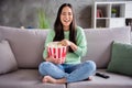 Full body photo of candid pretty korean girl sit divan legs bare foot crossed watch funny series laughing eat pop corn