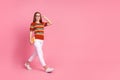 Full body photo of cheerful clever person hold book arm touch eyeglasses walk empty space isolated on pink color Royalty Free Stock Photo