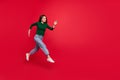 Full body photo of cheerful cute woman model run speed hurry buyer dressed stylish green clothes isolated on vivid red