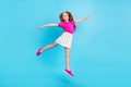 Full body photo of cheerful happy small girl jump up hands wings plane isolated on blue color background Royalty Free Stock Photo