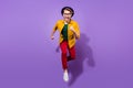 Full body photo of cheerful happy young man jump up run hurry sale good mood isolated on violet color background