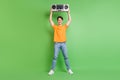 Full body photo of cheerful happy young man raise hands boombox music isolated on green color background