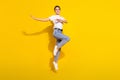 Full body photo of cool brown hairdo millennial lady dance wear white t-shirt jeans isolated on yellow color background Royalty Free Stock Photo