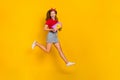 Full body photo of cool little girl run birthday wear t-shirt hairband skirt sneakers isolated on yellow background Royalty Free Stock Photo