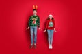 Full body photo of crazy lady and guy jumping high enjoy x-mas sale wear ugly ornament pullovers and headwear isolated