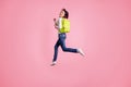 Full body photo of crazy lady jumping high holding green rucksack running autumn sale shopping wear pullover and jeans