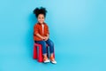 Full body photo of cute adorable sweet little girl sitting chair spend time in kindergarden isolated on blue color Royalty Free Stock Photo