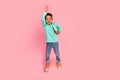 Full body photo of cute little boy jump raise arm answer lesson hold books wear trendy aquamarine clothes isolated on Royalty Free Stock Photo