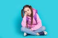 Full body photo of cute little girl sit floor moody backpack dressed stylish pink clothes isolated on aquamarine color Royalty Free Stock Photo