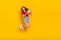 Full body photo of cute teenager girl jump hold present wear t-shirt hairband skirt footwear  on yellow Royalty Free Stock Photo