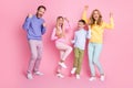 Full body photo of delighted family dad mom and two children scream raise fists isolated over pastel color background