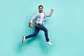 Full body photo of delighted overjoyed man hurry running jump isolated on teal color background