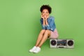 Full body photo of dream young lady sit with boom box wear dress shirt sneakers isolated on green background