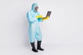 Full body photo focused man work laptop remote serach covid hazard information wear white suit hazmat yellow latex