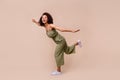 Full body photo of funky brunette woman play wear overall shoes isolated on beige color background Royalty Free Stock Photo