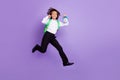 Full body photo of funky little brunet boy run hold clock wear bag shirt trousers sneakers isolated on purple background