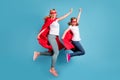 Full body photo of funny mom lady little daughter spend time together carnival super hero costumes jump high up raise Royalty Free Stock Photo
