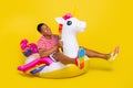 Full body photo of guy swim unicorn lifebuoy ocean wear red striped clothes isolated over bright yellow color background Royalty Free Stock Photo