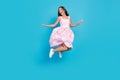 Full body photo of happy beautiful young woman jump look empty space fly skirt isolated on blue color background Royalty Free Stock Photo