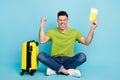 Full body photo of happy cheerful young man hold tickets luggage vacation isolated on blue color background