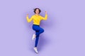 Full body photo of hooray young brunette lady jump yell wear shirt trousers sneakers isolated on purple background Royalty Free Stock Photo