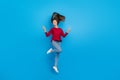 Full body photo of hooray young lady jump show v-sign wear eyewear shirt jeans shoes isolated on blue background Royalty Free Stock Photo