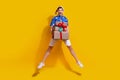 Full body photo of impressed overjoyed person jumping arms hold pile stack festive giftbox isolated on yellow color