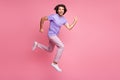 Full body photo of joyful brown haired young man jump run in air wear pink pants violet t-shirt isolated on shine pastel