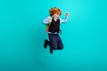 Full body photo of little energetic cheerful boy jumping carry backpack have fun isolated on teal color background