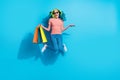 Full body photo of lovely overjoyed woman with shopping bags jumping up in air isolated on blue color background Royalty Free Stock Photo