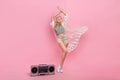 Full body photo of millennial blond lady dance near boombox wear top cape shorts sneakers isolated on pink background