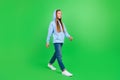 Full body photo of pretty small girl walking shopping sales poster dressed cozy trendy blue sweatshirt on green