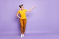 Full body photo of pretty teenager lady holding arm air showing big size length of new promoted product wear yellow t