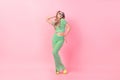 Full body photo of pretty young girl shopping dancer concert disco wear trendy green print outfit isolated on pink color Royalty Free Stock Photo