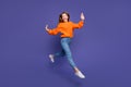 Full body photo of running in air teen schoolgirl orange sweater raised hands up fast escaping parents isolated on