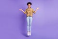 Full body photo of young african girl happy positive smile jumper wave hello isolated over purple color background Royalty Free Stock Photo