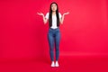 Full body photo of young attractive asian girl unhappy negative shrug shoulders clueless confused isolated over red Royalty Free Stock Photo